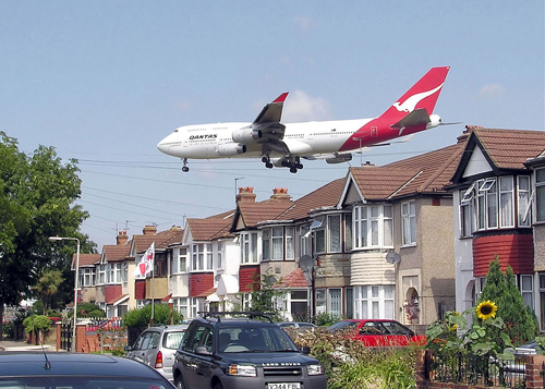 A Qantas Boeing 747-400 approaching runway 27L at London Heathrow Airport, England. The houses are in Myrtle Avenue, at the south east corner of the airport. Photographer’s note: I know this aircraft looks as though it was inserted in a graphics program but the picture is genuine. Aircraft pass close to Myrtle Avenue every 2 minutes when 27L is in use, so getting shots like this is easy. Photographed by Adrian Pingstone.